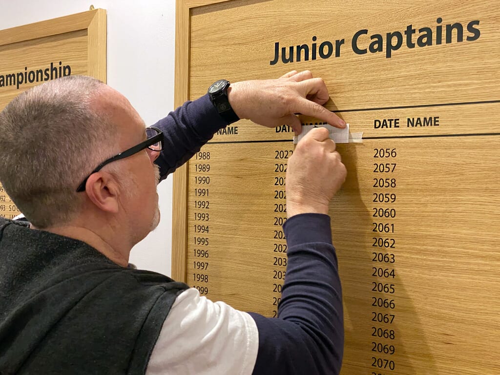 A School honours board with honours board lettering being put on.
